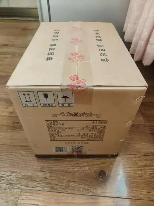 酿酒师的手正将金黄的高粱玉米倒入传统木甑中，蒸汽升腾，展现了东北粮食酒酿造的第一步：选粮与蒸粮。_1