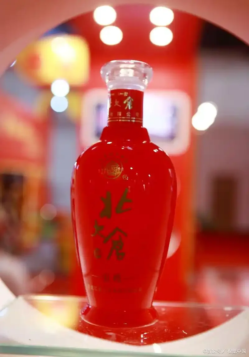 一瓶45度北大仓部优酒与品酒杯的静物特写，背景虚化，光线柔和，展现酱香型白酒的质感与品鉴场景。_1