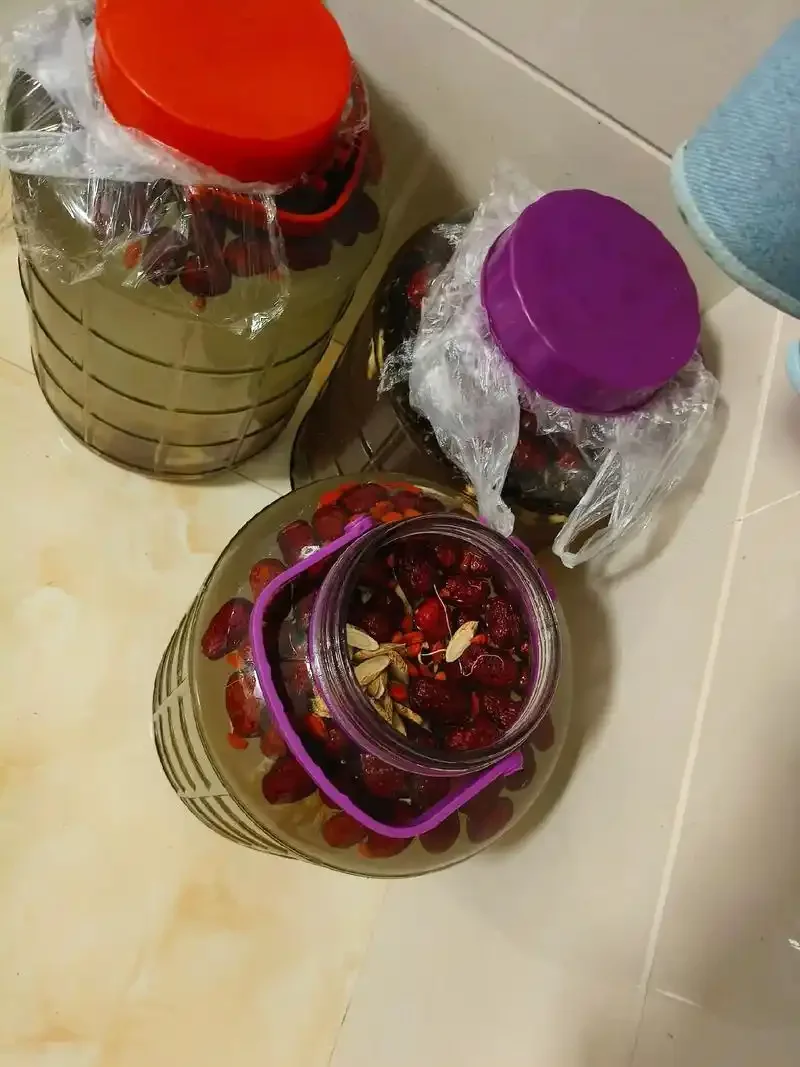 展示几种不同药材在透明玻璃瓶中浸泡的药酒特写照片，光线柔和，突出药材形态与酒液色泽。_1