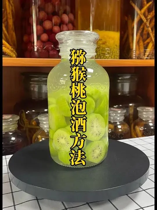 酿酒师正在将切片的金黄色猕猴桃放入透明玻璃酒坛中，准备泡制猕猴桃酒。_1