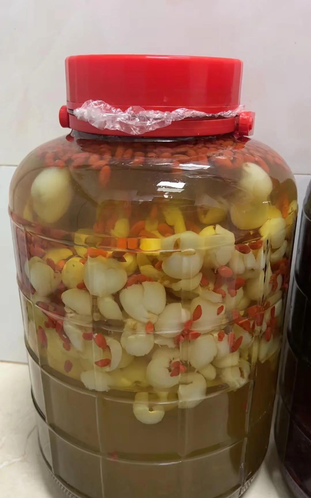 家庭自制消瘤果泡酒过程展示：透明玻璃罐中金黄色的酒液与消瘤果完美融合。_1