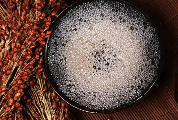 酿酒师将白酒倒入量筒，产生细密持久的白色酒花，用于观察酒质_1