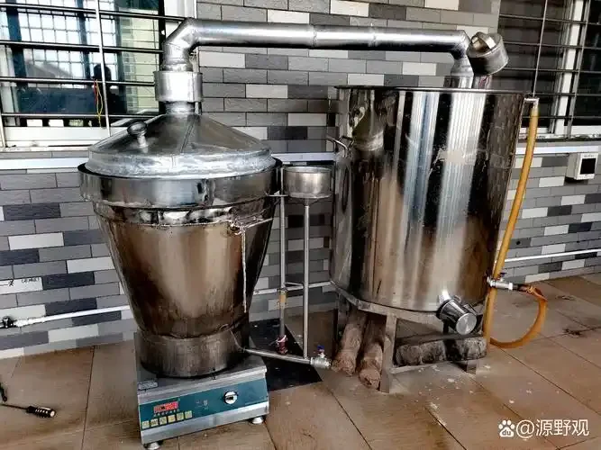 小型酒厂车间内连接好的不锈钢酿酒设备实景照片，展示了发酵罐、蒸煮锅和不锈钢管道系统。_1