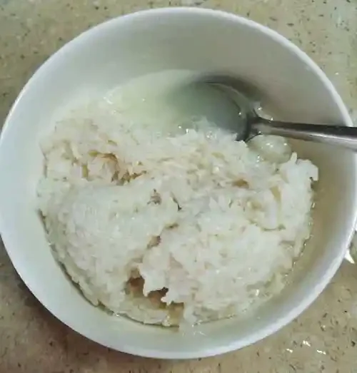 酿酒师用手感知米酒发酵温度，罐中米粒饱满，酒液清亮，背景有温度计和笔记本。_1