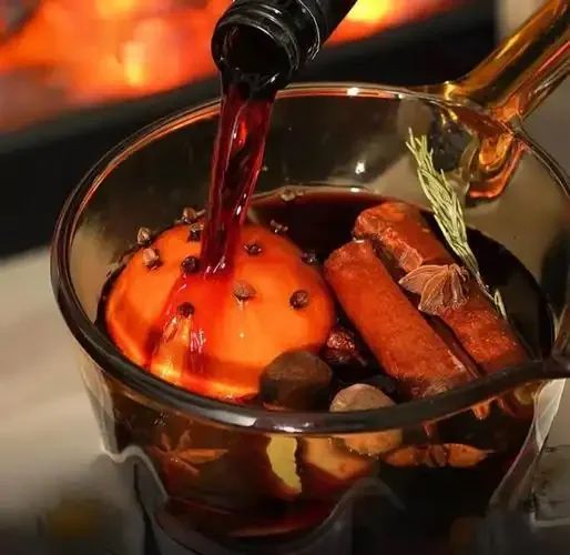 铸铁锅慢煮热红酒的冬日厨房场景，锅中可见橙子片、肉桂等香料_1