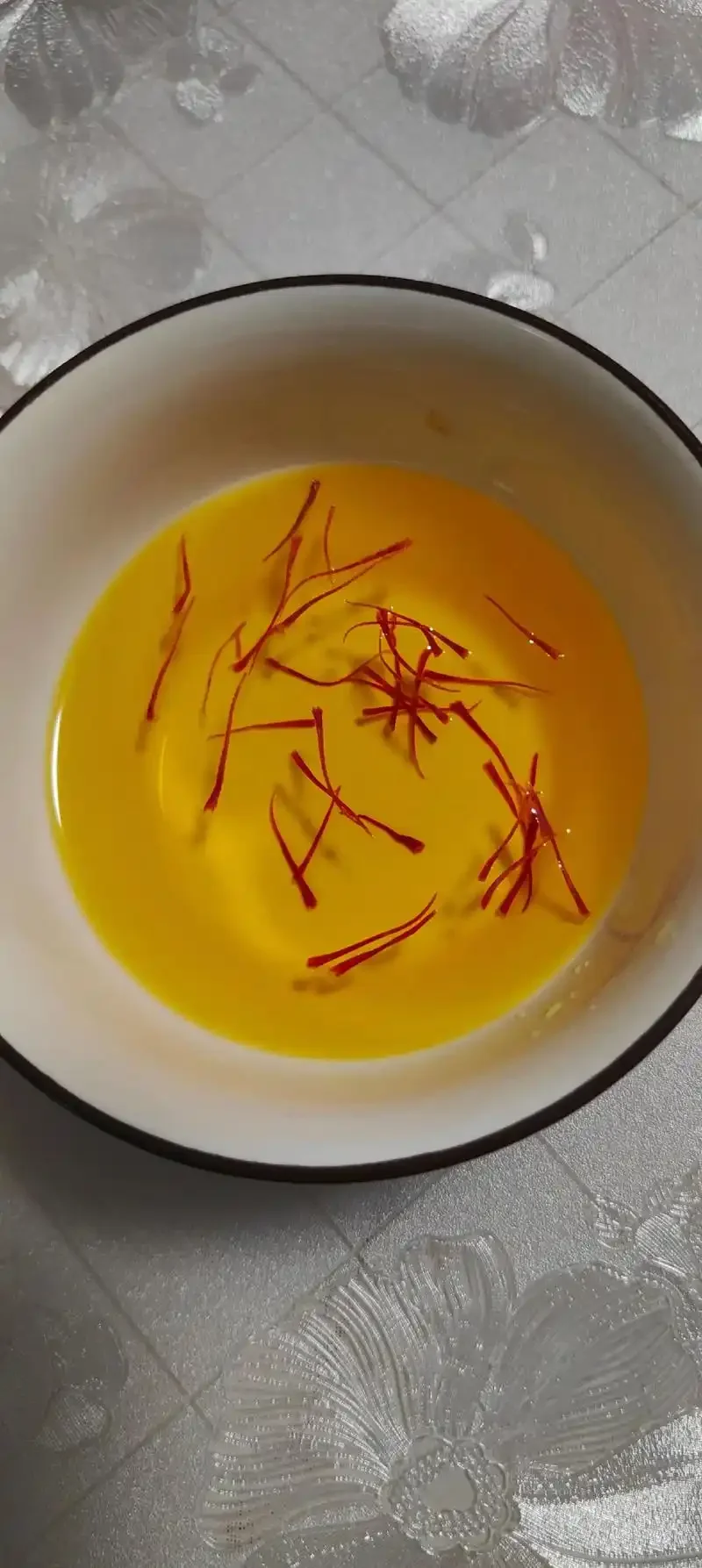 五味子藏红花泡酒成品特写：玻璃罐中琥珀色酒液，红色藏红花与深色五味子清晰可见_1