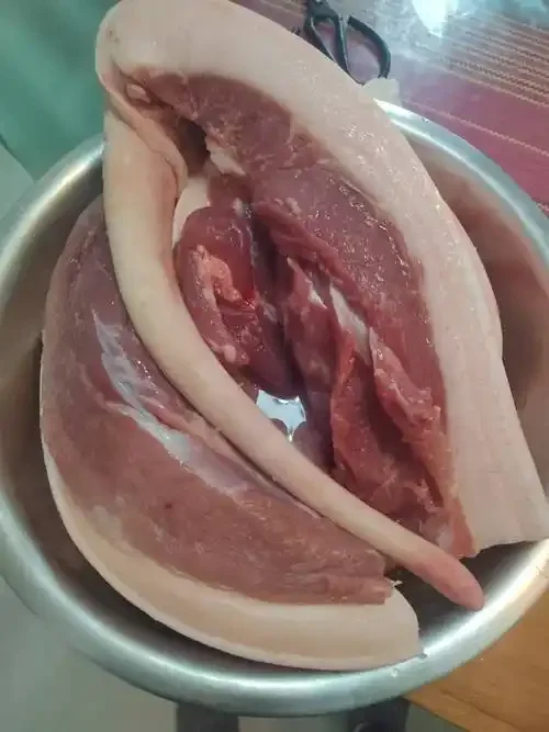 腌腊肉材料特写：猪肉、50度纯粮白酒、盐和香料，展示传统腌制食材准备。_1
