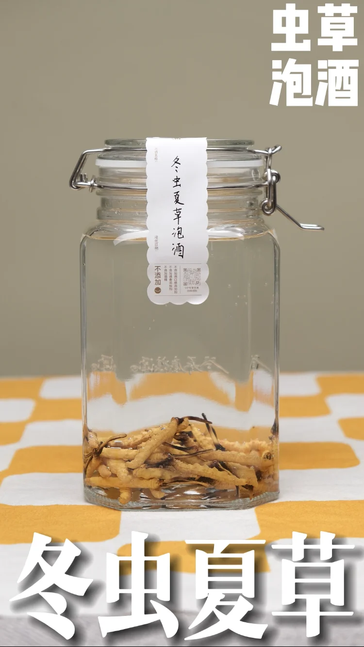 虫草、枸杞、人参泡在透明玻璃瓶酒液中的特写照片，展示了家庭自制滋补药酒的经典搭配。_1