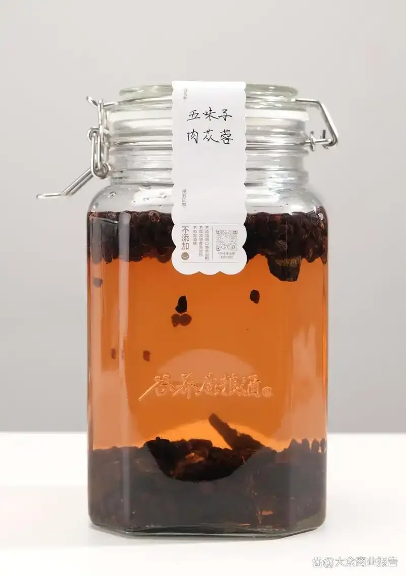 管花肉苁蓉泡酒过程展示：玻璃罐中浸泡着切片肉苁蓉的淡琥珀色酒液，旁边辅以红枣、枸杞等配料。_1