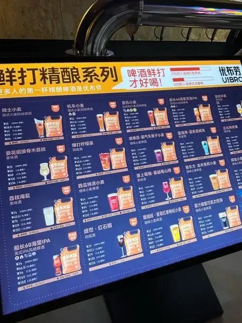 酿酒师在精酿啤酒厂车间内品鉴啤酒，背景是不锈钢发酵罐_1