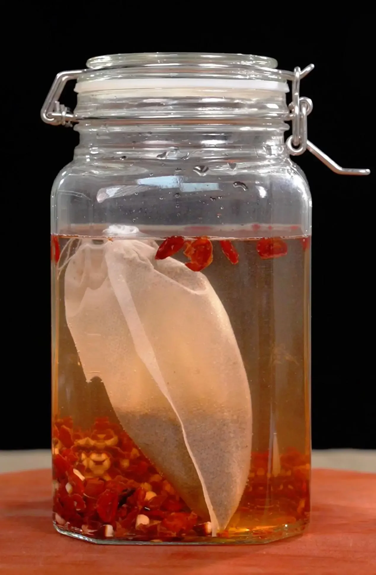 泡制中的养生药酒玻璃罐特写，内含多种中药材，展示正确的浸泡状态。_1