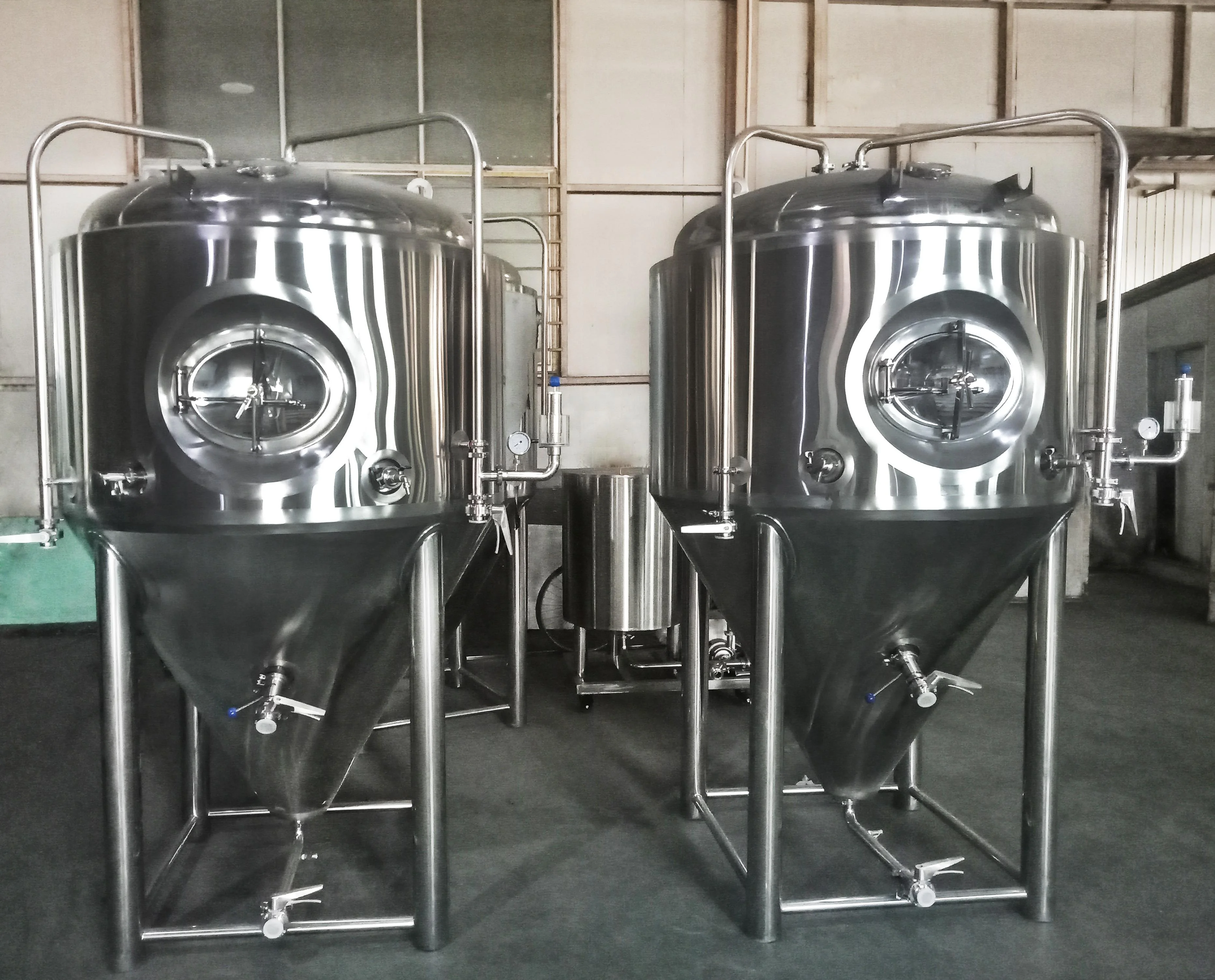 家庭自酿啤酒设备工作场景：不锈钢煮沸锅、糖化桶和透明发酵罐整齐摆放，爱好者正在操作_1