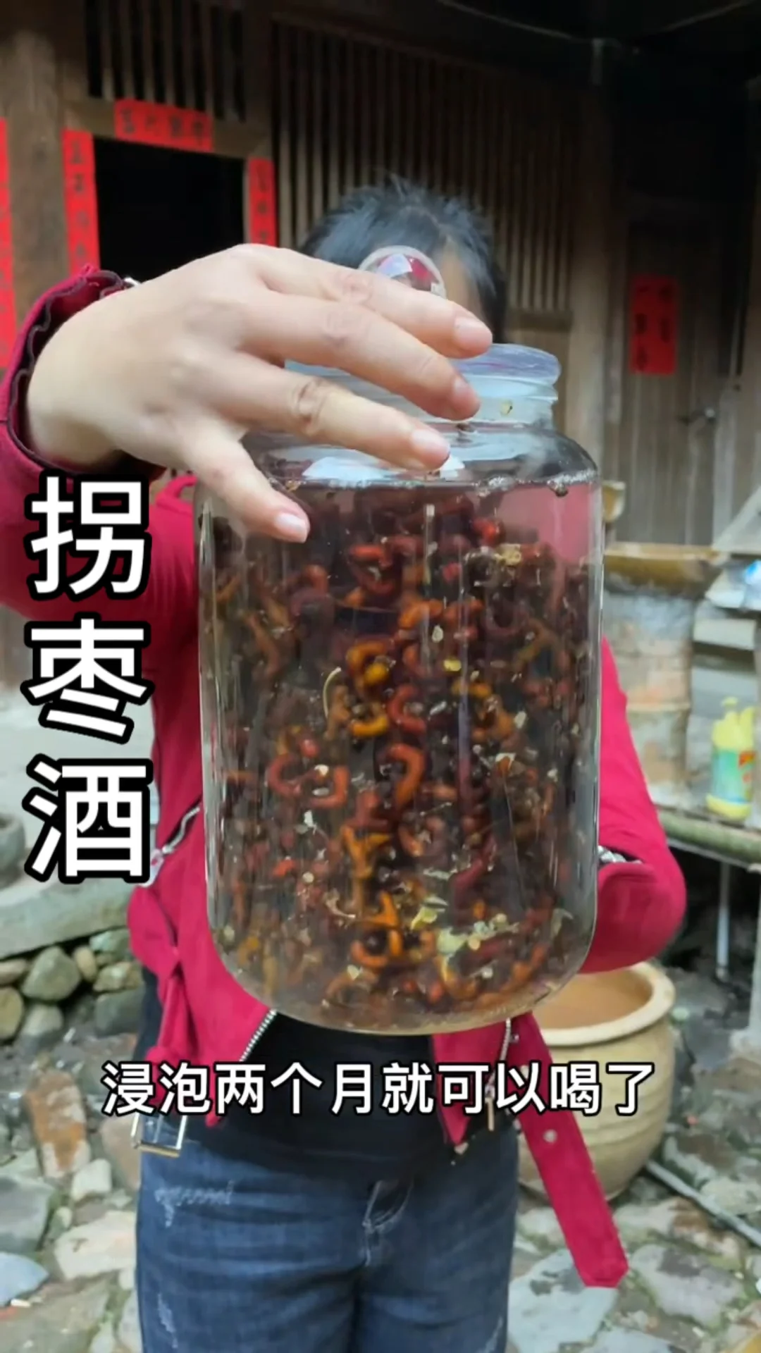 一个装满琥珀色酒液和金黄色拐子的透明玻璃泡酒坛，展示拐子泡酒的成品状态_1