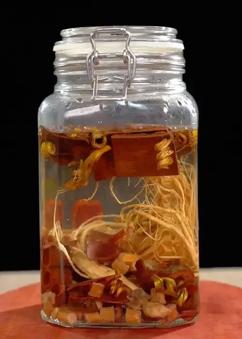 虎头蜂与中药材在透明玻璃酒坛中被高度白酒浸泡的特写照片_1