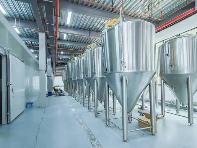 酿酒师在小型酿造室内操作不锈钢啤酒酿造设备，检查麦汁状态_1