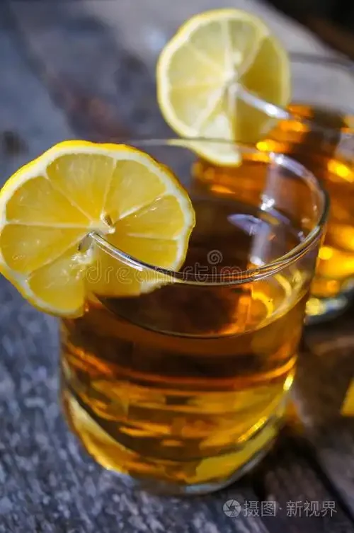 白酒与柠檬搭配的工作台：一瓶白酒、切片柠檬和一杯混合酒液，展示白酒调饮的探索过程。_1