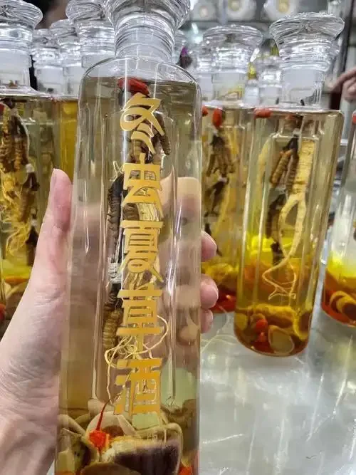 人参虫草泡酒配方展示：透明玻璃罐中的琥珀色药酒，内含完整人参和金色虫草，背景为木质桌面，体现家庭自制药酒的专业与安心。_1