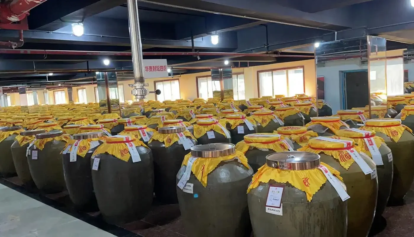 茅台镇酱酒厂传统蒸馏车间，工人正在操作木甑桶进行蒸馏出酒，蒸汽弥漫，展现了酱酒酿造的核心工艺环节。_1