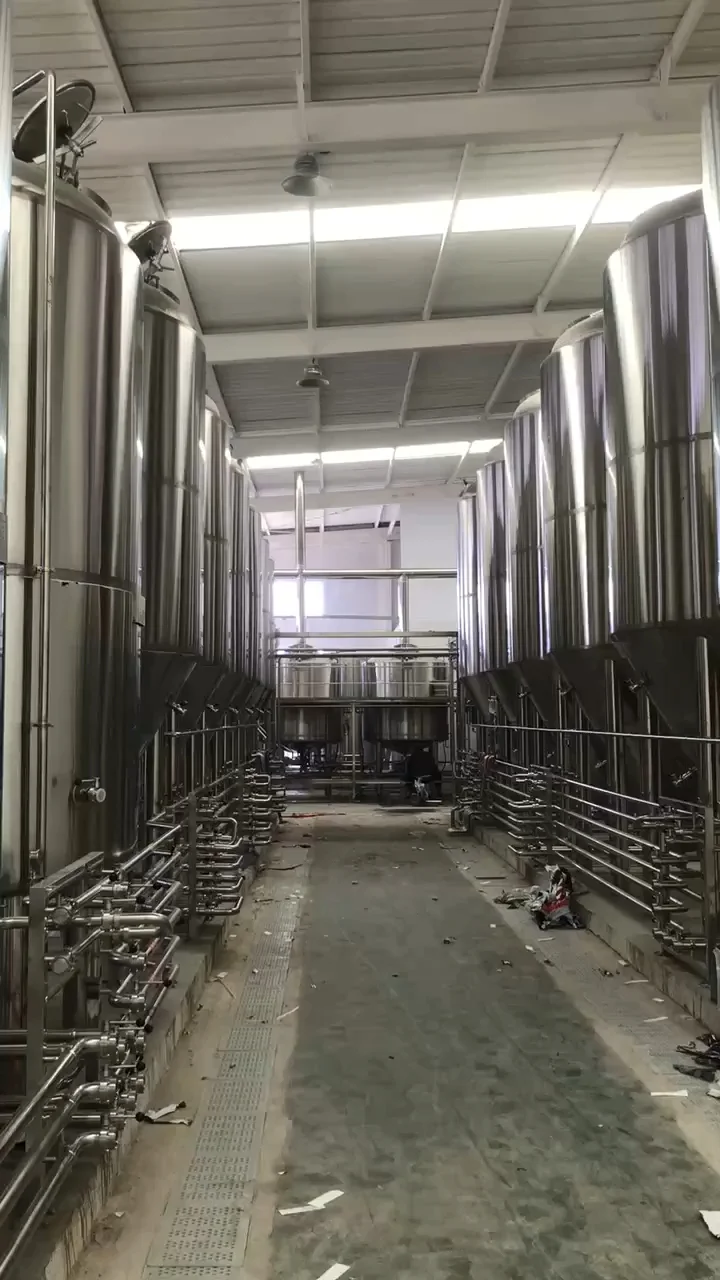 辽宁某酿酒作坊内,一套不锈钢酿酒设备正在工作,旁边堆放着高粱原料和陈年酒坛。_1