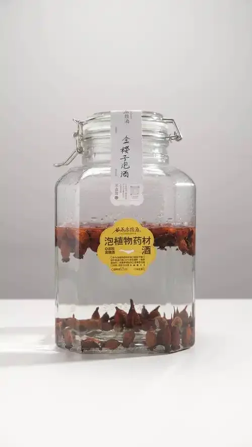 一瓶清澈的金樱子根药酒，旁边散落着药材切片，展示家庭泡酒的质朴与专业。_1
