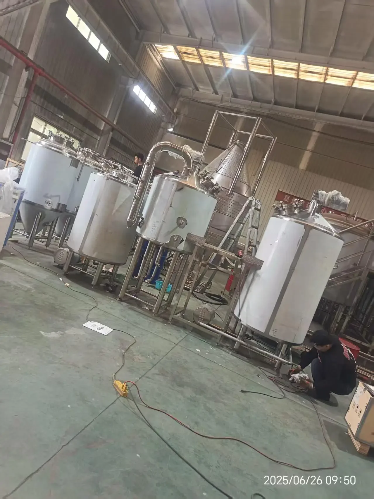 一套完整的不锈钢小型酿酒设备，包含蒸煮锅、冷凝器和连接管路，摆放在整洁的工作台上。_1