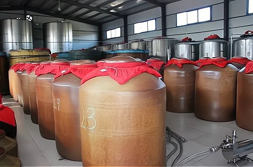 小型酿酒作坊内部布局实景图，展示蒸煮区、发酵区与整洁的工具存放区_1