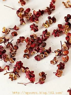 自制花椒泡酒静物图：玻璃罐中红色花椒在琥珀色酒液中浸泡，旁边有配方纸条。_1