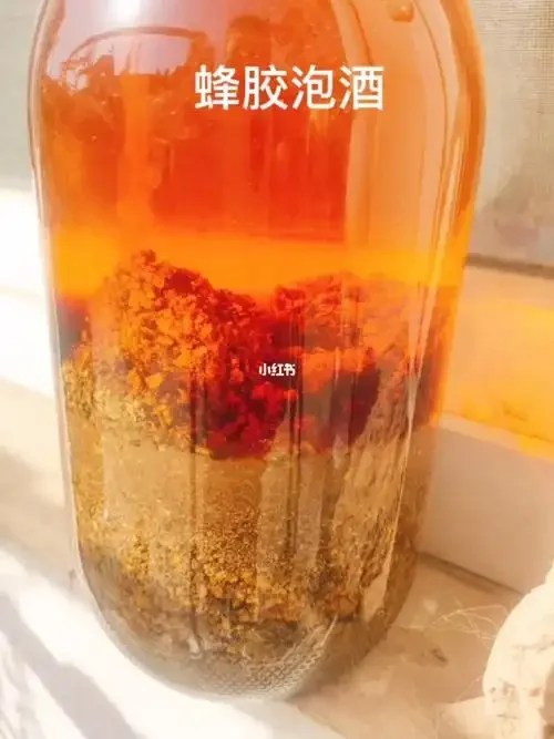 见血清泡酒的每日用量展示：一瓶琥珀色药酒和一个盛满标准量酒液的小酒盅。_1