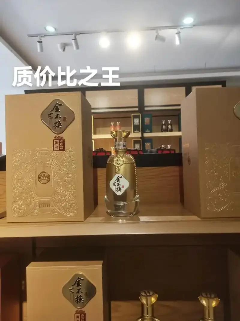 金不换泡酒药材与器具展示：透明玻璃罐中浸泡着金黄色的金不换根片、红枣和枸杞，旁边摆放着原料与白酒。_1