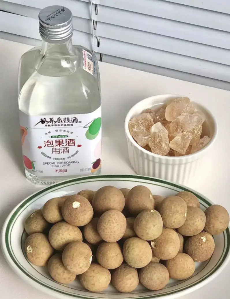自制龙眼干泡酒过程展示：玻璃罐中龙眼干与白酒的黄金配比，旁边放置电子秤和龙眼干货源。_1