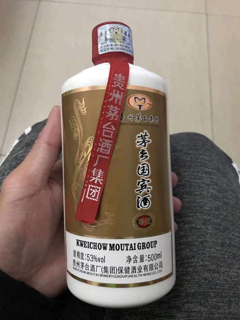 一瓶正在浸泡中的自制参茸三七酒，清晰可见瓶内的红参、鹿茸和三七药材，酒体色泽琥珀通透。_1