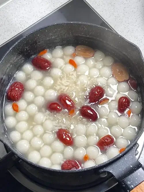 一碗制作成功的酒酿丸子汤特写，展示其清澈汤底、软糯丸子和诱人色泽。_1