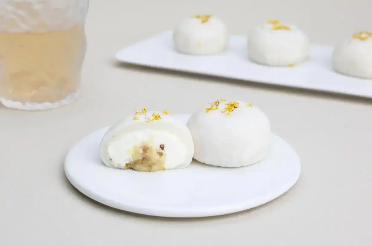 大曲桂花酒发酵过程特写：玻璃罐中金黄桂花与粮食混合发酵，旁边有新鲜桂花、酒曲和酿酒笔记。_1