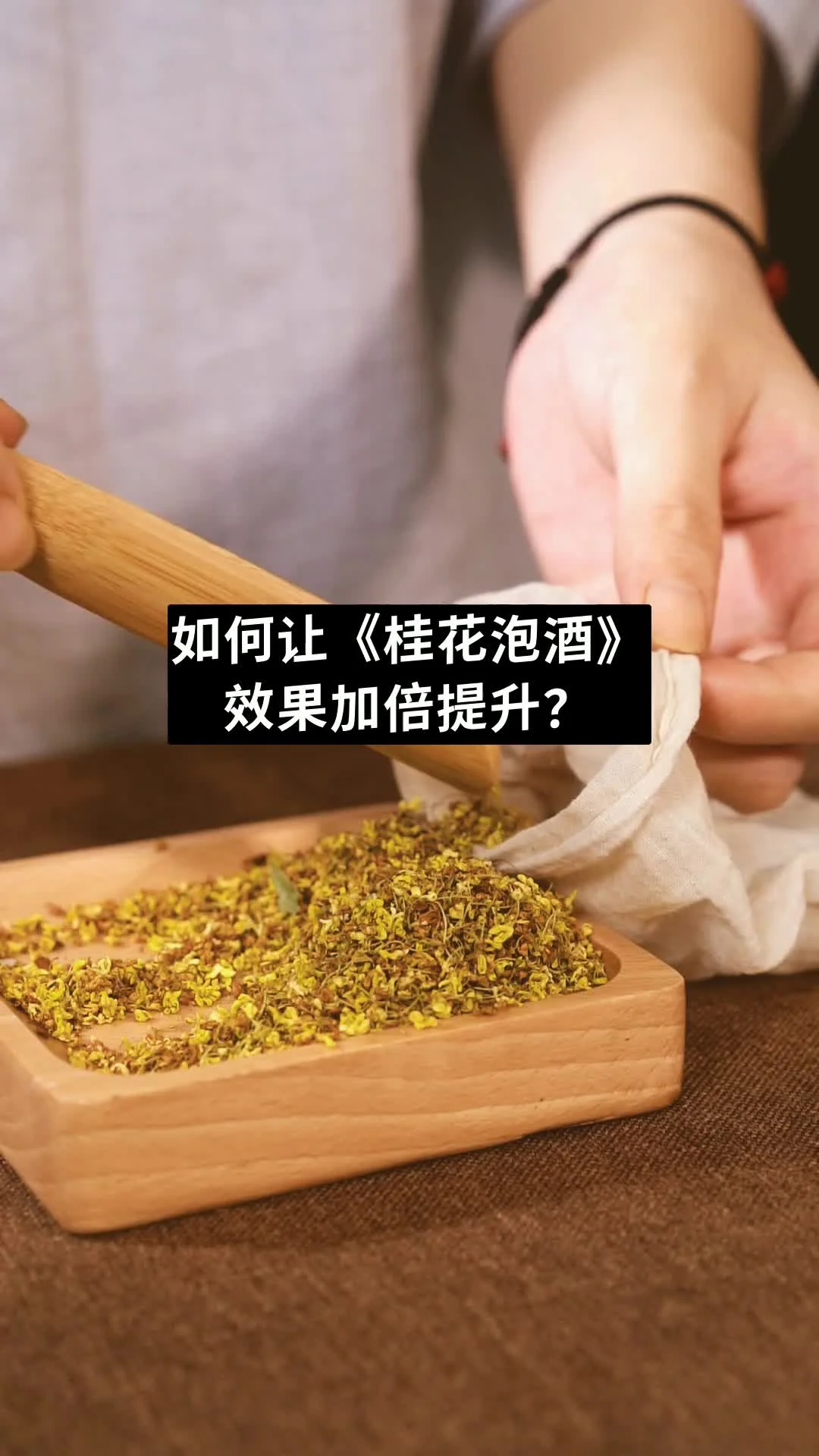 正在浸泡中的家庭自制桂花酒特写，金黄桂花与清澈酒液层次分明，旁边摆放着原料桂花和冰糖。_1