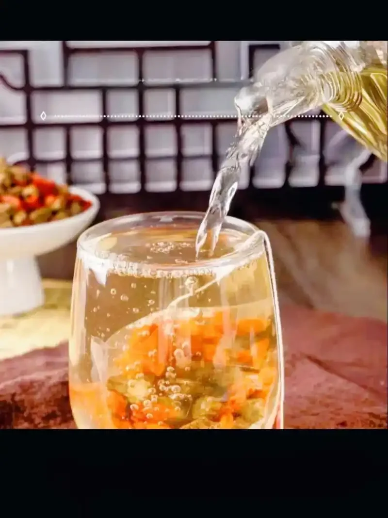 家庭自制川断枸杞泡酒过程展示：透明玻璃罐中浸泡着川断和枸杞，酒液呈琥珀色。_1