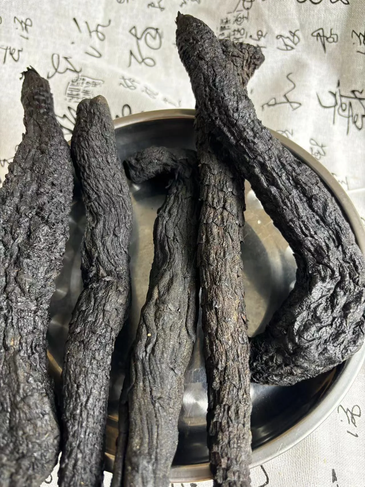 酿酒师工作台上对比展示干肉苁蓉与鲜肉苁蓉，以及用于泡酒的玻璃瓶和酒液_1