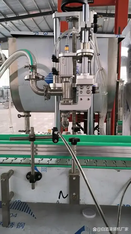 酿酒车间内不锈钢半自动酒类灌装机正在精准灌装白酒至玻璃瓶中的工作场景特写_1