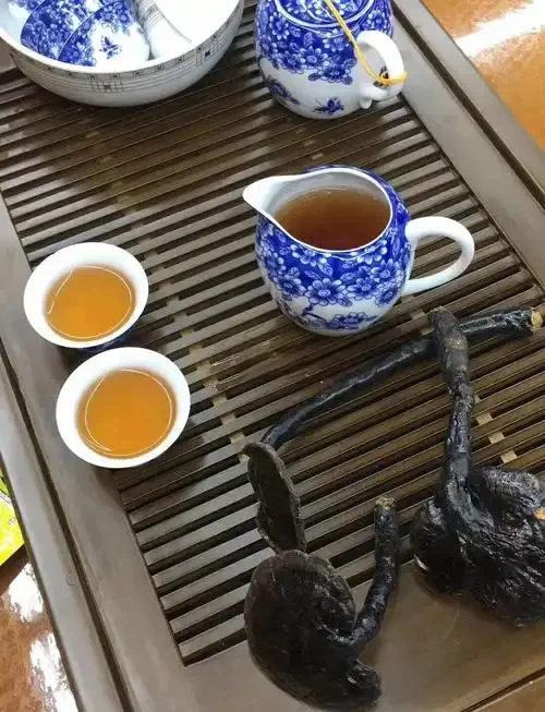 自制野生灵芝泡酒展示：透明玻璃罐中琥珀色酒液浸泡着完整灵芝，佐以枸杞和黄芪_1