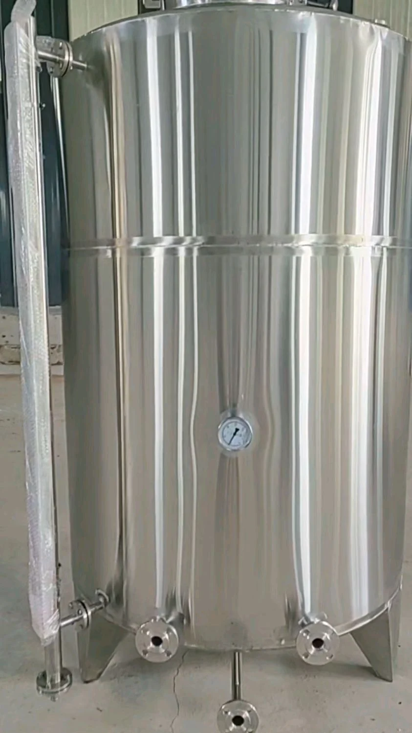 资深酿酒师在酿造车间检查大型不锈钢白酒储酒罐_1