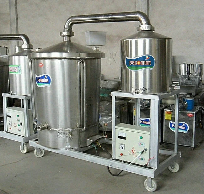 资深酿酒师工作室中的不锈钢小型多功能白酒蒸馏设备，旁边摆放着刚蒸馏出的清澈新酒。_1