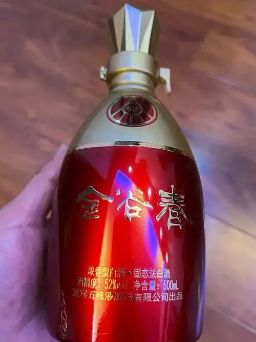 一瓶极具收藏价值的经典白酒静置于木质酒柜上，光线柔和，氛围沉稳，象征着时间与价值的沉淀。_1