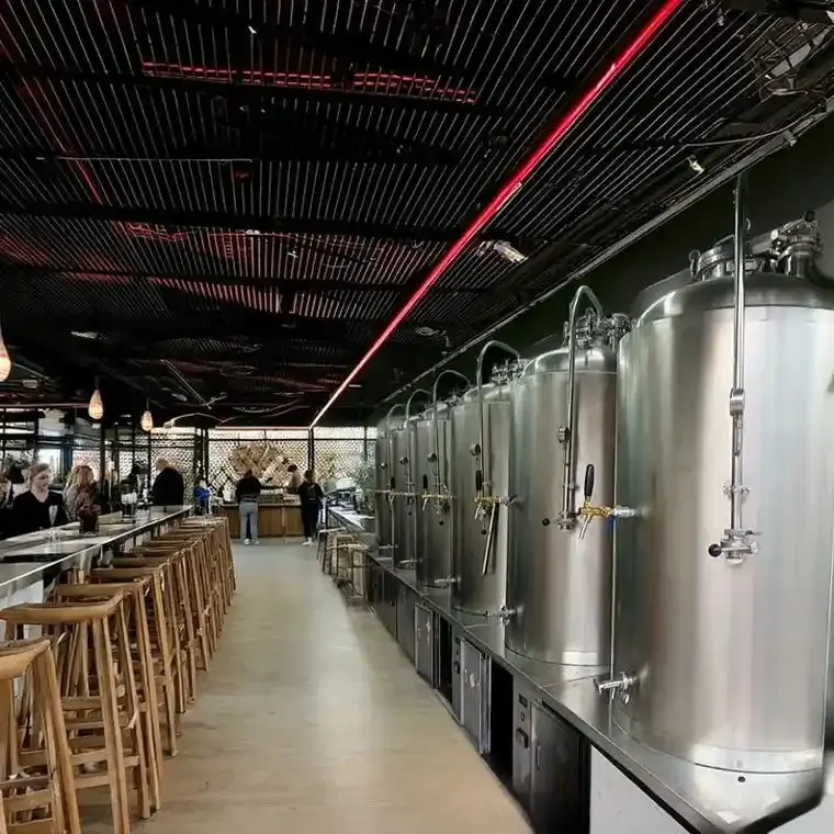 专业啤酒屋内，酿酒师正在操作和维护闪亮的不锈钢一体式啤酒酿造设备_1
