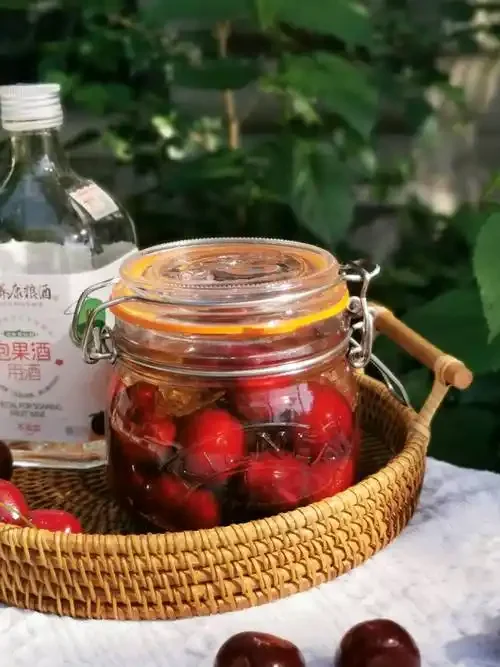 家庭自制樱桃酒发酵过程特写：玻璃罐中深红色樱桃与琥珀色酒液_1