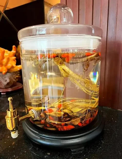 石斛海马泡酒成品展示：玻璃瓶中琥珀色酒液浸泡着完整海马与石斛段_1