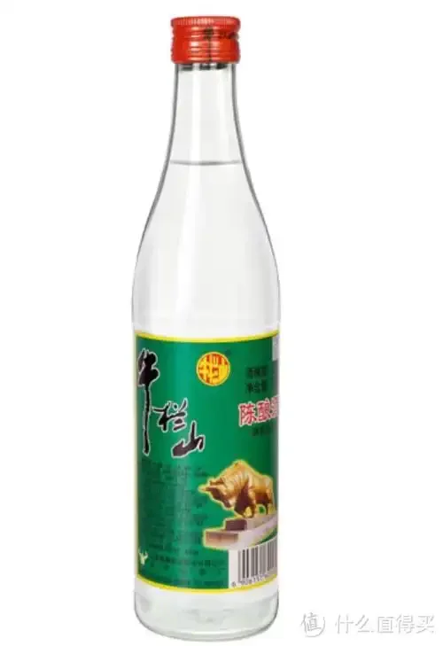 一位老酒友在家中餐桌旁，专注地观察杯中酒液的颜色，桌上摆放着几款不同的白酒，营造出真实、温馨的日常饮酒场景_1