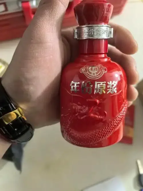 传统酱香型白酒从陶坛倒入品鉴杯的特写，展现酒体浓稠的挂杯和油亮质感，背景为古朴的酿酒窖池环境。_1