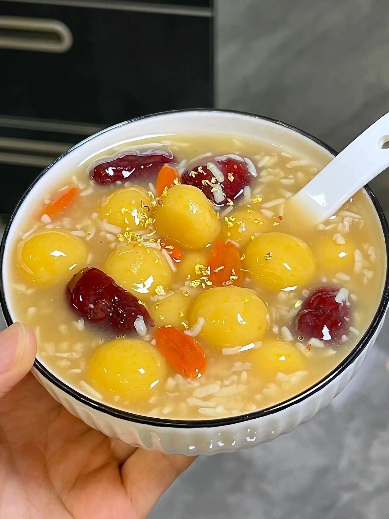 一碗热气腾腾、蛋花与米酒交融的甜白酒冲鸡蛋，旁边放着白净的汤圆，展示甜白酒的经典吃法。_1