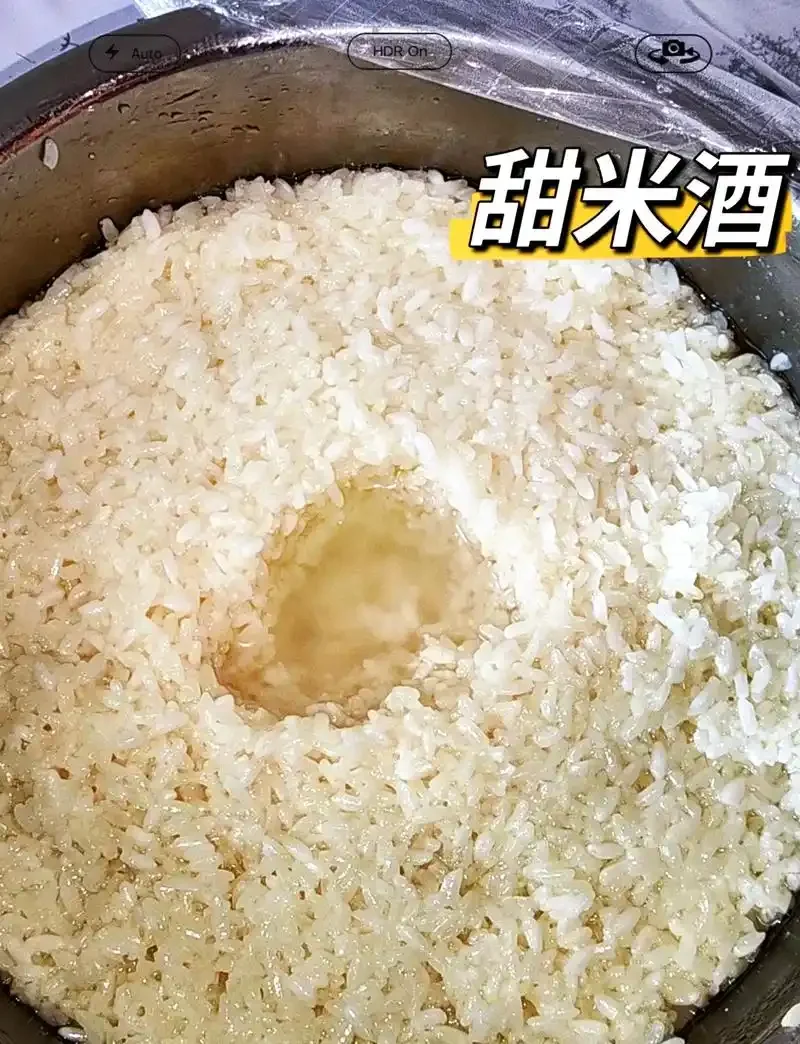 装在透明玻璃罐中的琥珀色米酒，旁边配有青花瓷碗和木勺，展示了家庭保存米酒的理想方式。_1