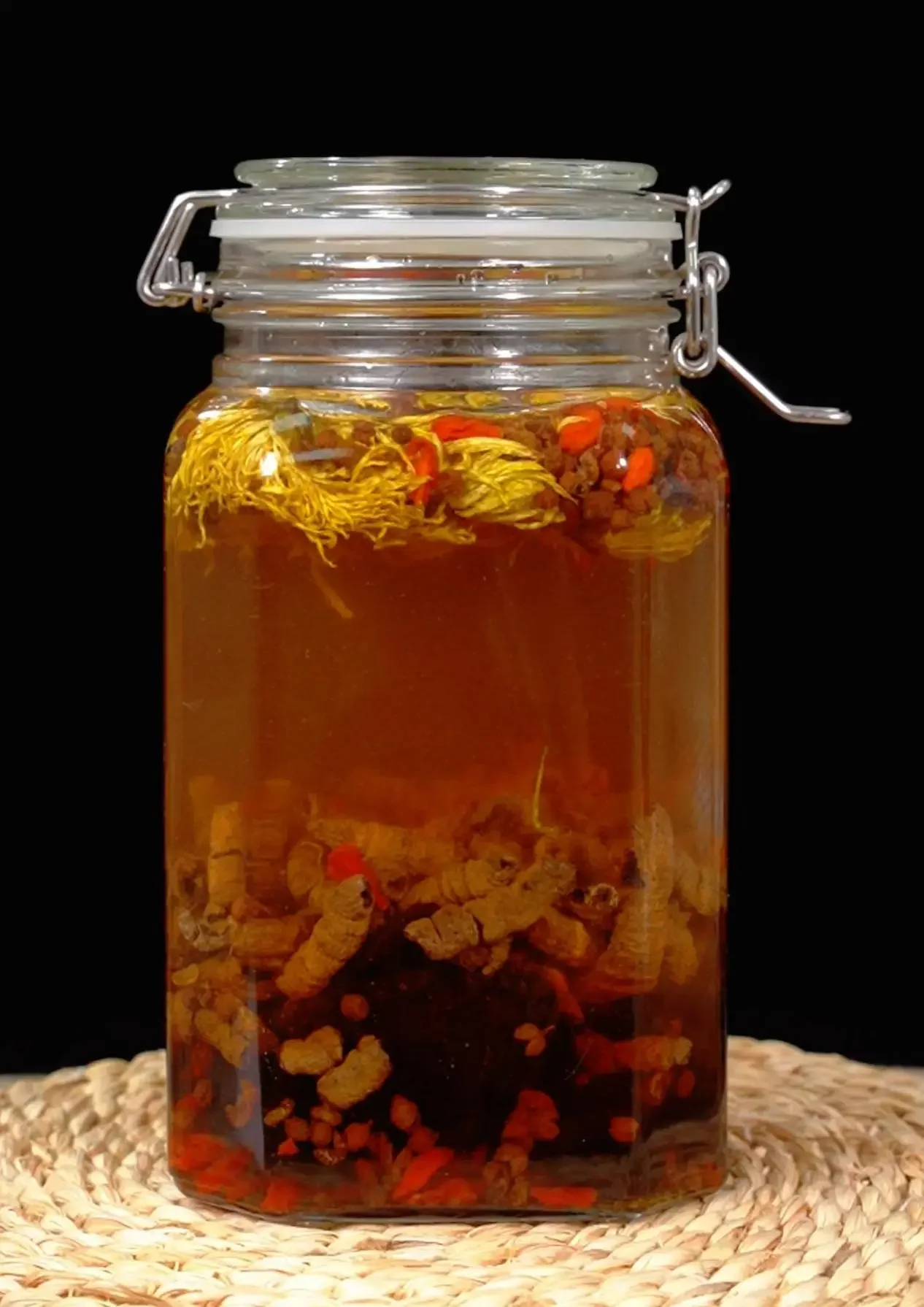 专业酿酒师展示的透明泡酒瓶，内含人参、枸杞等中药材的养生药酒_1