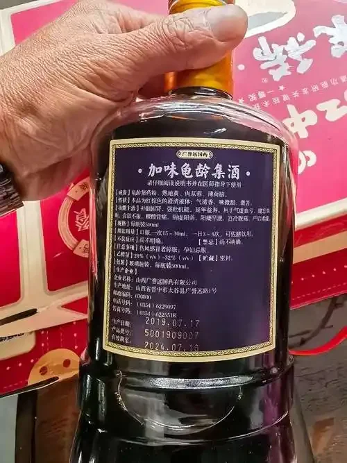 一瓶700毫升远字牌龟龄集酒与多种中药材（人参、鹿茸、枸杞等）摆放在一起的展示图_1